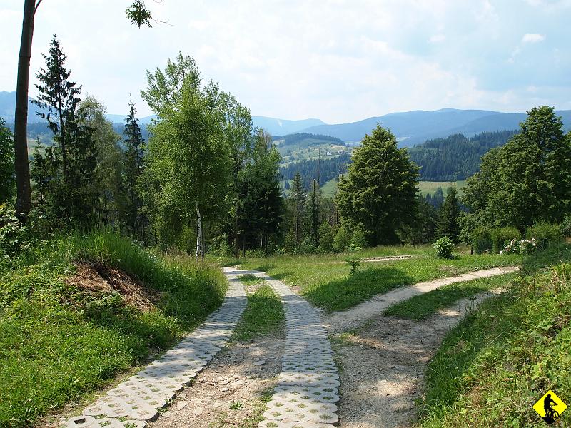 P7011490.JPG - Gdy minie się już wieżę radio jakąś tam :) , a zarazem stację piątą, można wreszcie dosiąść swojego rumaka i trochę pokręcić. Szczyt ma 1064m i jest zalesiony, ale powolna wspinaczka pozwala podziwiać roztaczające się widoki.