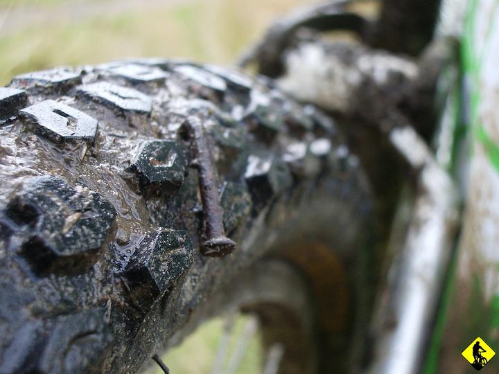 IMGP3690.JPG - Aga powiedziała kiedyś, że jak tak bedę zjeżdżał to się to źle skończy. Nie wiem czy spotkanie z matką ziemią było już TYM "źle się skończy", czy tylko ostrzeżeniem przed nim. Ogólnie chodzi mi o to, że zaliczam uślizg przedniego koła w koleinie.  Pamiętam tyle, że uderzam kaskiem o kamienie i zdzieram wszystko co mam z prawej strony. Gdy zjawia się Jurek to już stoję i oglądam "straty". Gdy już wiem, że jeszcze żyję dociera do nas obrazek ze zdjęcia. A na focie jest opona Jurka i mała niespodzianka