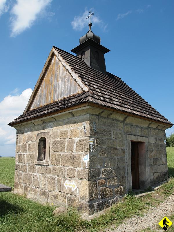 P7212046.jpg - W pobliżu szczytu stoi murowana kapliczka, ufundowana ok. 1910 roku przez Jana Koska. Jest pokryta gontem, wewnątrz znajduje się figura Chrystusa upadającego pod krzyżem po raz trzeci z nazwiskiem fundatora. Jak głosi podanie, rzeźbę zamówiono w Sidzinie dla Kalwarii Zebrzydowskiej. Podczas transportu trzy pary wołów zatrzymały się na grzbiecie nad Bogdanówką i nie chciały się ruszyć z miejsca. Uznano to za bożą wolę i wybudowano w tym miejscu kaplicę, w której umieszczono rzeźbę.